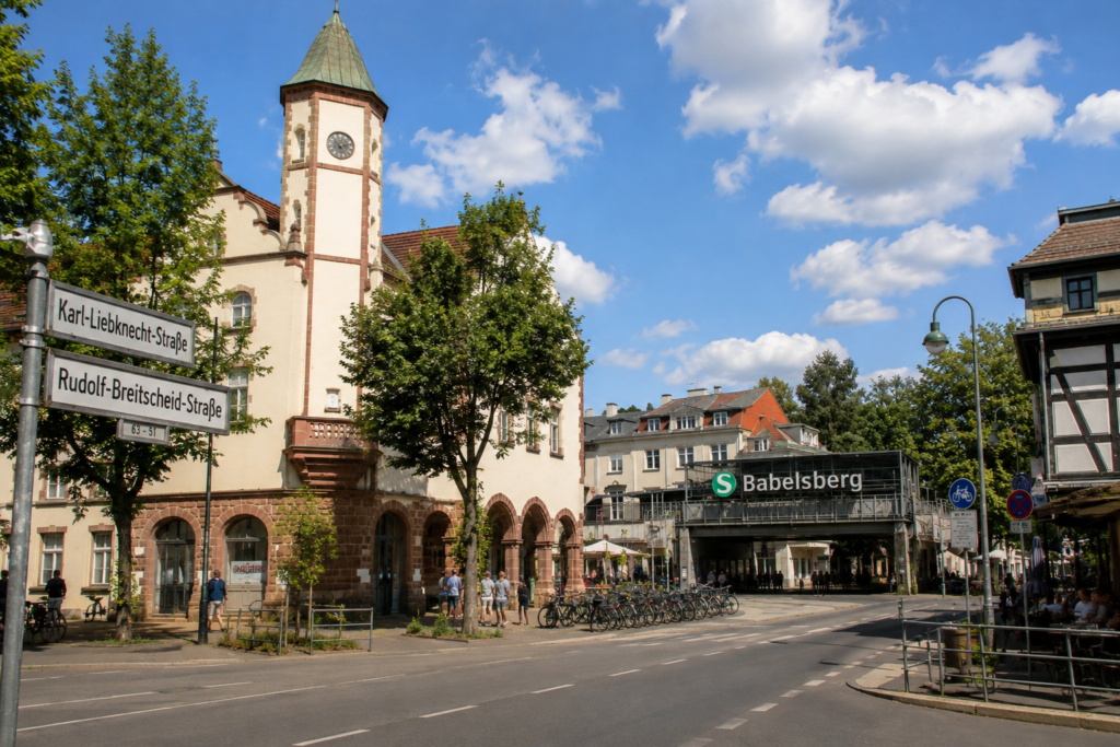 Babelsberg in Potsdam an einem sonnigen Tag mit historischem Rathaus, Bahnhof Babelsberg, belebter Straßenszene und typischer Architektur des beliebten Stadtteils.